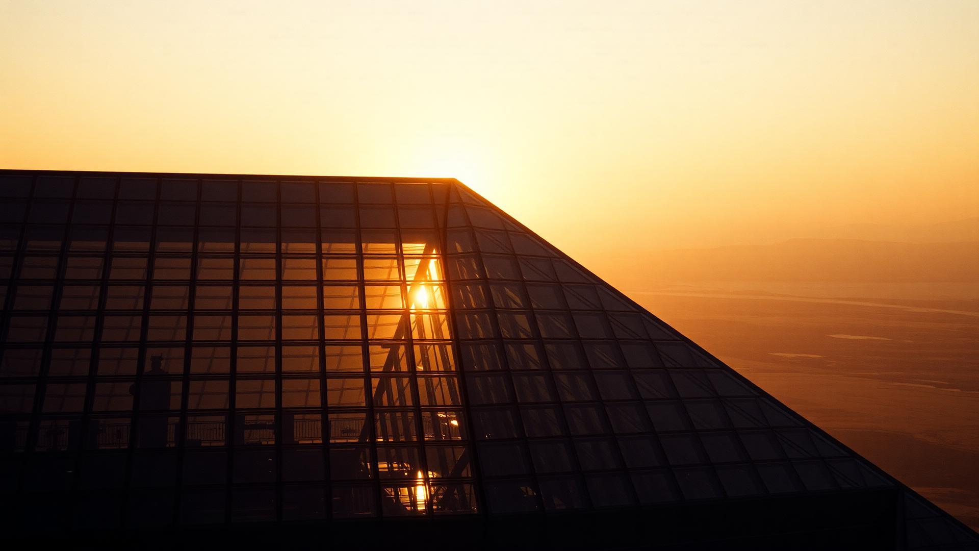 Monumental glass architecture catching sunset light.