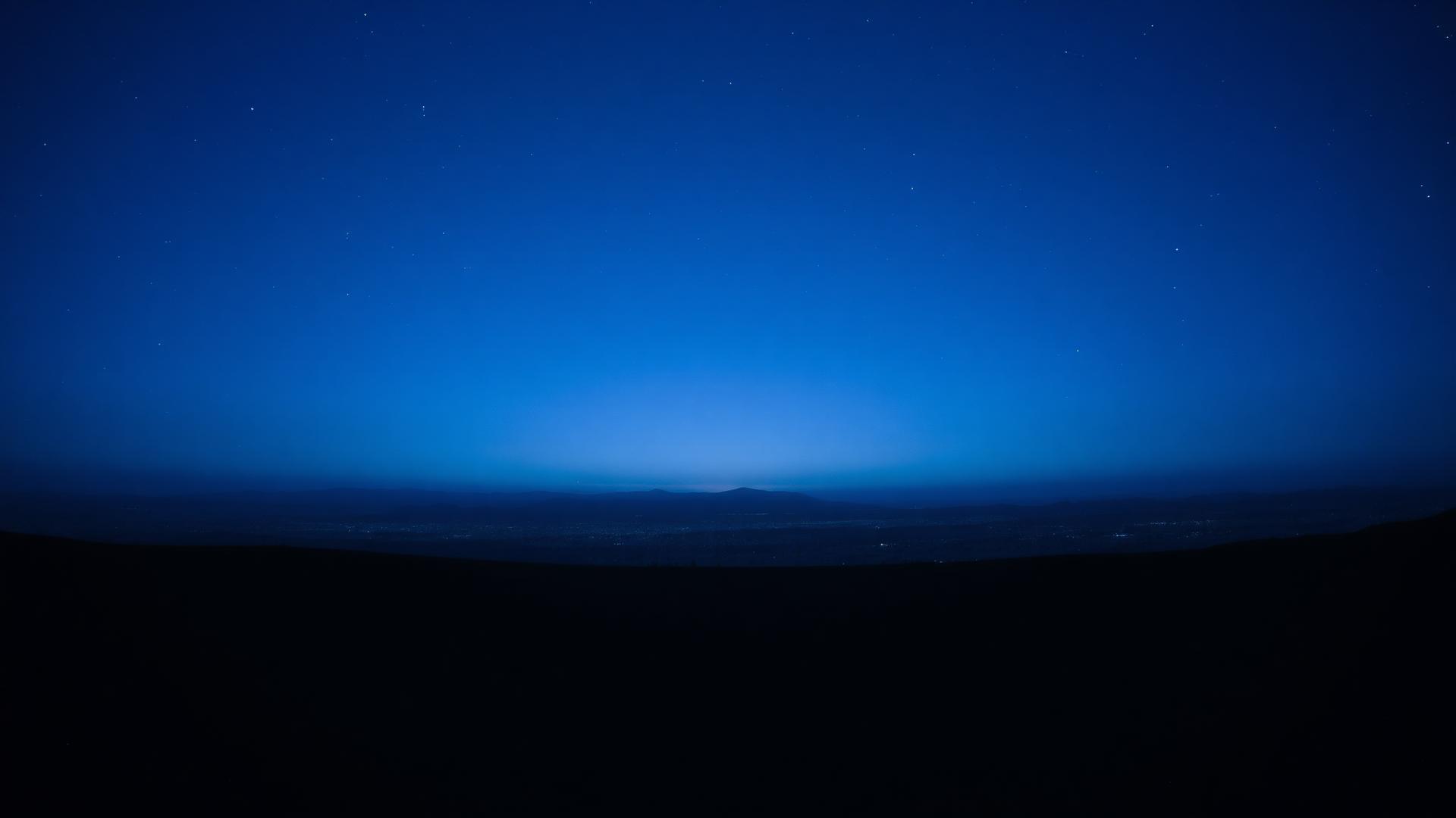 Twilight sky opening into a field of stars.